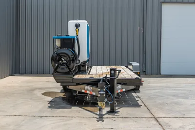 2026 Behnke TBCT2220ET-BT-R HDD trailer, front view, wood deck, hose reel, white poly tank, blue pump unit, tongue jack