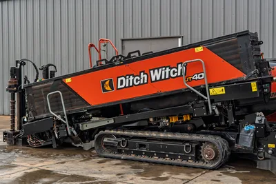 2021 Ditch Witch JT40 HDD drill, angled side view showing steel tracks, drill frame, hydraulic lines, and orange JT40 branding panel
