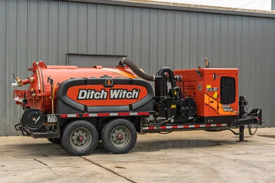 2023 Ditch Witch HX50 mud recycler, driver-side view, tandem-axle trailer, orange vacuum tank, engine enclosure, vacuum hose visible