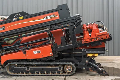 Side view of 2012 Ditch Witch JT3020 Mach 1 HDD drill showing carriage, hydraulic assembly, steel tracks, and engine bay.