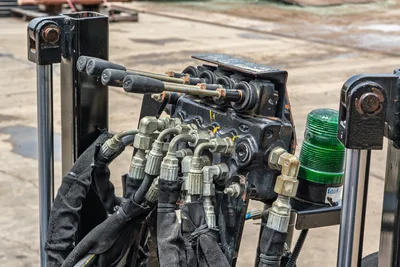 2018 Ditch Witch JT10 hydraulic valve block with spool controls, AN fittings, bundled hoses, and green strobe beacon