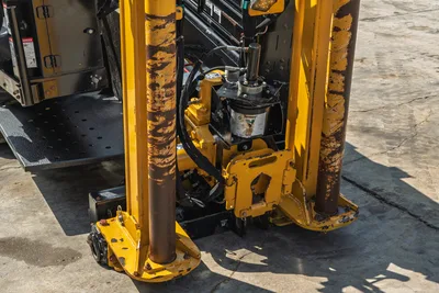 Vermeer D23x30 S3 HDD drill frame close-up showing spindle, hydraulic rotary head, wear-marked guide rods, and anchor feet