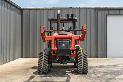 2024 Ditch Witch RT125Q rear view, rubber tracks, ROPS frame, exhaust stack, engine cover with logo, plow blade assembly, low hours