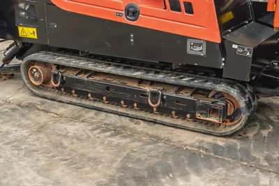 Side view of 2021 Ditch Witch JT25 HDD drill featuring rubber tracks, steel undercarriage, and lower engine bay panels.