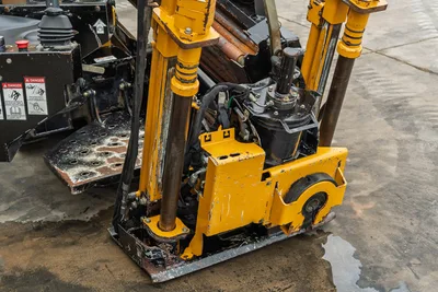 2018 Vermeer D8x12 HDD drill carriage close-up showing spindle, hydraulic motor, guide rods, and wear-used yellow frame