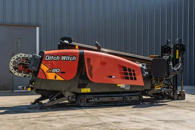 Side profile of 2018 Ditch Witch JT20 HDD drill rig, showing tracks, operator seat, engine compartment, and drill pipe rack.