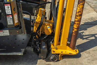 2022 Vermeer D23x30 S3 drill frame base, vise assembly, hydraulic hoses, safety decals, and wear-marked drill pipe visible