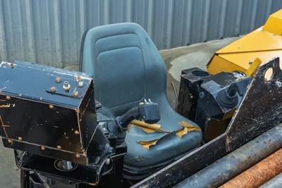 Vermeer D23x30 S3 operator seat with worn armrest, joystick controls, electrical panel, and yellow engine hood visible at rear