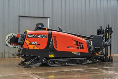 Ditch Witch JT20 compact HDD rig, side view, red/orange body, tracked undercarriage, drill head left, mud system right, 74 hp, 17,000 lbs thrust