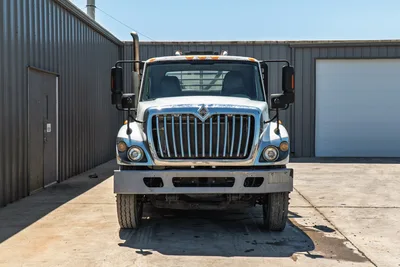 2015 International 7400 HDD mud truck, straight-on front view, chrome grille, dual mirrors, exhaust stack, steel bumper, work-worn condition