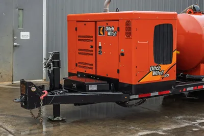 2021 Ditch Witch HX50 mud recycler on trailer, front 3/4 view, orange enclosure with louvered panels, tongue hitch with safety chain
