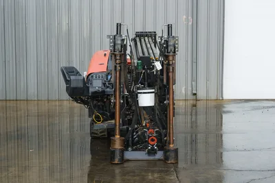 2015 Ditch Witch JT20 HDD drill, rear view showing drill rack, pipe loader, hydraulic lines, operator seat, and orange engine hood