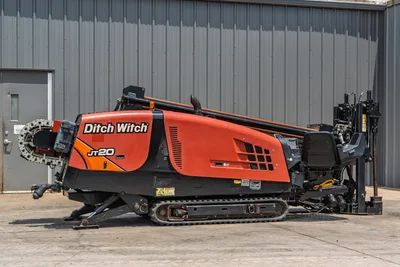2017 Ditch Witch JT20 HDD rig, full profile view, orange bodywork, rubber tracks, drill pipe loaded, pipe rack, vise assembly visible