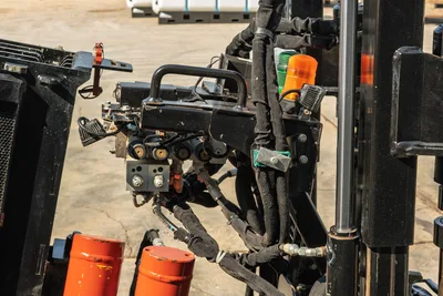 Ditch Witch JT24 hydraulic control manifold, hose assembly, and beacon light assembly, close-up side view.