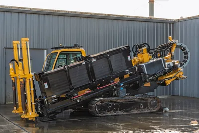 Vermeer 40x55DR S3 HDD unit with 40,000 lbs thrust, tracked carrier, yellow/black paint, drill head rotary assembly, pipe handler arms, enclosed cab, side profile view