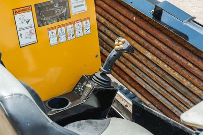Vermeer 10x15 S3 cab interior with joystick control, warning decals, and 1.66" drill pipe bundle displayed adjacent