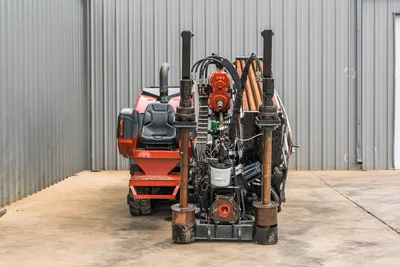 2021 Ditch Witch JT28 HDD drill, rear view showing carriage, drill pipe rack, hydraulic hoses, spindle, operator seat, and rubber tracks