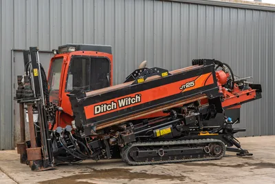 2016 Ditch Witch JT25 HDD drill, driver-side view, enclosed cab, rubber tracks, drill pipe loaded on angled carriage