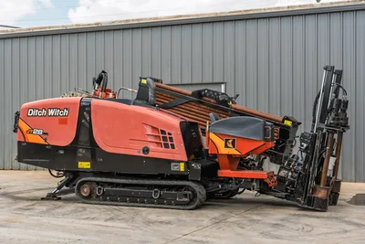 2021 Ditch Witch JT28 HDD drill, driver-side 3/4 view, rubber tracks, loaded drill pipe rack, angled carriage with vise assembly