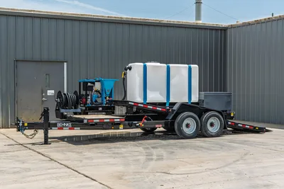Behnke TBCT2220ET-BT-R HDD mud mixing trailer, driver-side view, white poly water tank, blue mixer unit, hose reel, tandem axle, black steel frame