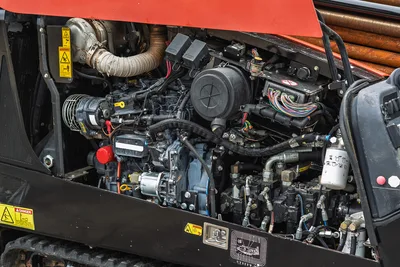 Exposed 74 hp engine compartment of 2018 Ditch Witch JT20, showing clean hydraulic pumps, air intake, and wiring harness.