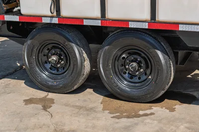 Vermeer LP873SDT vacuum excavator trailer dual axle tires, black steel wheels, red reflective tape, tan tank visible above frame
