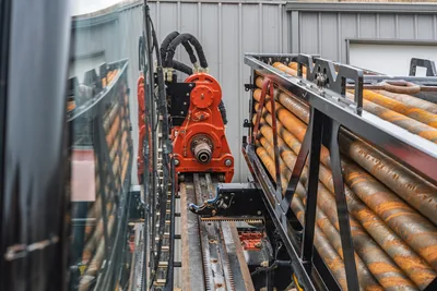 2021 Ditch Witch AT40 All Terrain carriage and pipe box rack system showing drill pipes, track rack, and rotation drive.