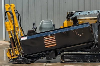 2021 Vermeer D8x12 HDD drill side view showing operator seat, drill pipe rack, yellow carriage, hydraulic lines, and rubber tracks