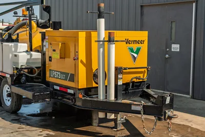 2024 Vermeer LP573SGT vacuum excavator, side profile view of engine compartment, spoil tank, and tongue-mounted tool rack.