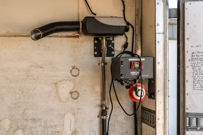 Interior wall-mounted diesel heater and Tripp-Lite PR-40 power supply inside Freightliner FL80 mud truck equipment bay.