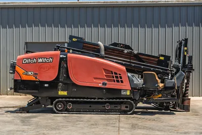 2018 Ditch Witch JT30 All Terrain HDD rig, driver-side profile, rubber tracks, loaded drill pipe rack, operator seat visible