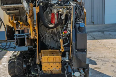 2016 Vermeer D23x30 S3 rear engine compartment showing hydraulic cooling fan, mud pump, hoses, and emergency stop button