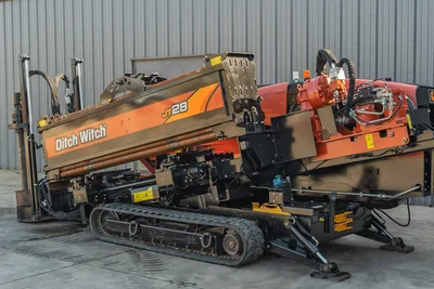 2021 Ditch Witch JT28 HDD drill, 3/4 front view, drill pipe loaded on carriage, rubber tracks, hydraulic components visible