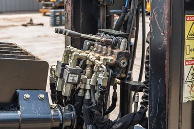 2017 Ditch Witch JT20 hydraulic valve block, fittings, hoses, and control lever; wear-patina finish; danger labels visible