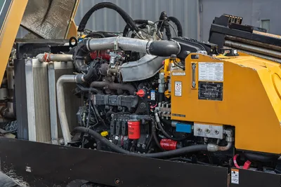 2018 Vermeer D24x40 S3 open engine compartment showing diesel engine, turbo, hydraulic lines, oil filter, and lubricant chart on yellow panel