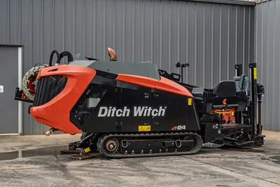 2024 Ditch Witch JT24 HDD drill, side profile, rubber tracks, drill rod loader, operator station, red/black bodywork, exhaust stack visible