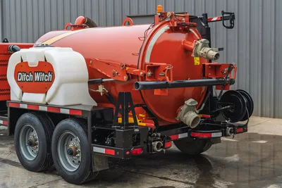 Rear quarter view of 2019 Ditch Witch HX30 vacuum excavator, debris tank, water tank, hose reel, and tandem trailer chassis.