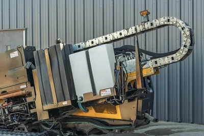 2021 Vermeer D23x30 S3 HDD rig rear/side view showing cable carrier drag chain, fluid tank, hydraulic lines, and rubber tracks