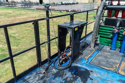 2023 American Augers M300DH mud recycler deck with hydraulic hoses, pump assembly, black steel railing, and blue-painted platform surface.