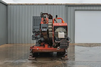 Rear view of 2008 Ditch Witch JT4020 MACH 1 showing mud pump, drill pipe rack, engine housing, and hydraulic stabilizers.
