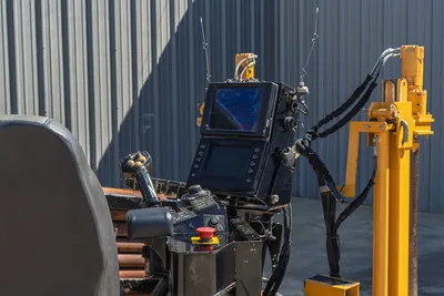 Vermeer D40x55 S3 operator console with dual display screens, joystick controls, red E-stop button, antennas, and yellow pipe rack visible