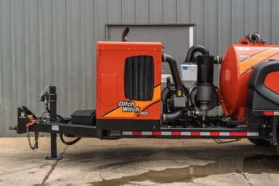 2023 Ditch Witch HX50 mud recycler on trailer, side view showing orange engine enclosure, exhaust stack, pump assembly, and 800-gal tank