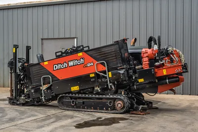 2024 Ditch Witch JT24 HDD drill, 3/4 side view, rubber tracks, red carriage, operator console, hydraulic lines visible