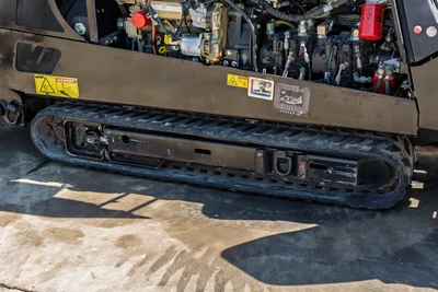 Side view of 2018 Ditch Witch JT20 engine compartment, hydraulic pump assembly, and robust rubber tracks.
