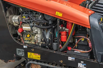 Open engine compartment of 2018 Ditch Witch JT10 horizontal directional drill showing filters, wiring, and radiator fan.