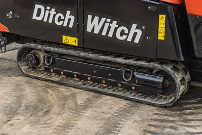 Close-up side view of 2021 Ditch Witch AT40 rubber track undercarriage and main chassis frame with safety decals.