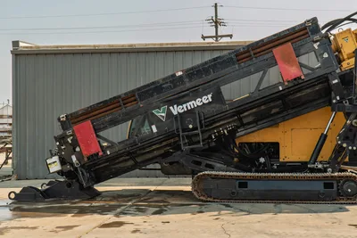 2017 Vermeer D100x140 S3 drill rig angled side view, loaded pipe rack with 3.5" drill pipe, rubber tracks, front anchor