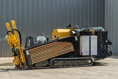 Vermeer 10x15 S3 HDD rig side view with yellow drill pipe magazine, black chassis, track drive, and control cab