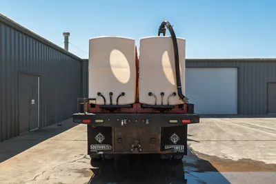 2015 International 7400 HDD mud truck, rear view, dual white poly mixing tanks, manifold valves, flex hose, worn rear bumper