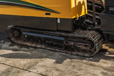 2018 Vermeer D24x40 S3 HDD rig steel undercarriage track close-up, worn with mud, yellow machine body visible above